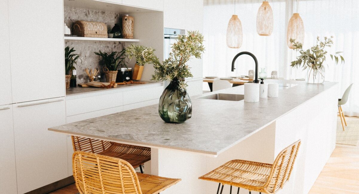 Interior Design: Helle, moderne Küche in weiss mit grauer Arbeitsplatte und Barhocker.
