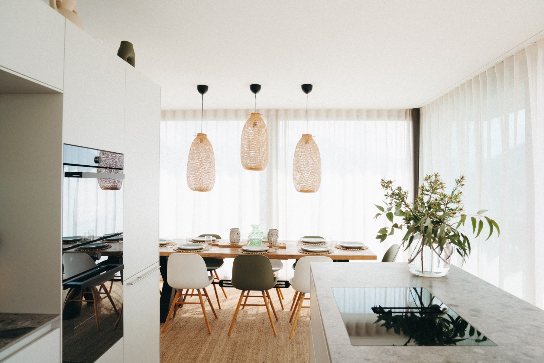 Blick aus Küche in Essbereich mit 3 Hängelampen, Esstisch und Stühlen