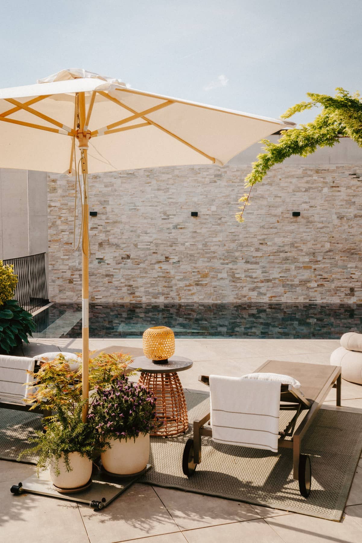 Pool-Design auf Terrasse mit zwei Liegestühle und Sonnenschirm